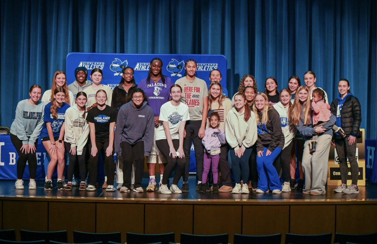 The basketball team gets together for a picture to celebrate athletes Marrisa Green (12) and Ty Berry (12) on their signings.